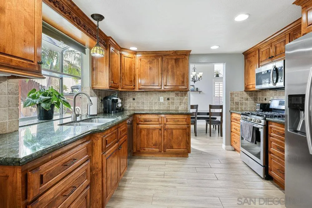 790 Mosaic Circle Oceanside, CA 92057 - Photo 24 of 47 a kitchen with stainless steel appliances granite countertop a stove a sink and a refrigerator