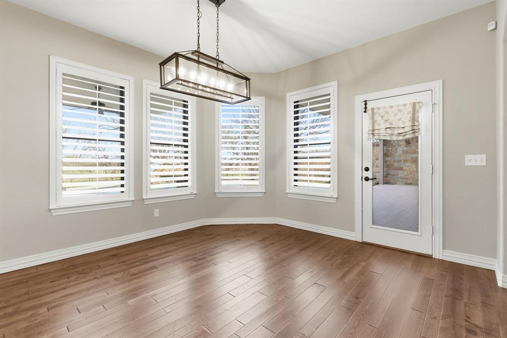 8970 Burnett Road Justin, TX 76247 - Photo 14 of 39 a view of an empty room with wooden floor and a window
