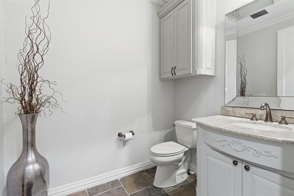 8970 Burnett Road Justin, TX 76247 - Photo 21 of 39 a bathroom with a toilet sink and mirror