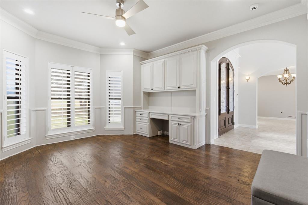 8970 Burnett Road Justin, TX 76247 - Photo 22 of 39 an empty room with wooden floor cabinet and a fireplace