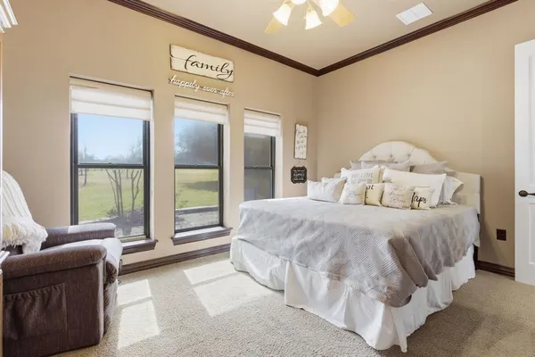 a bedroom with a bed and a large window