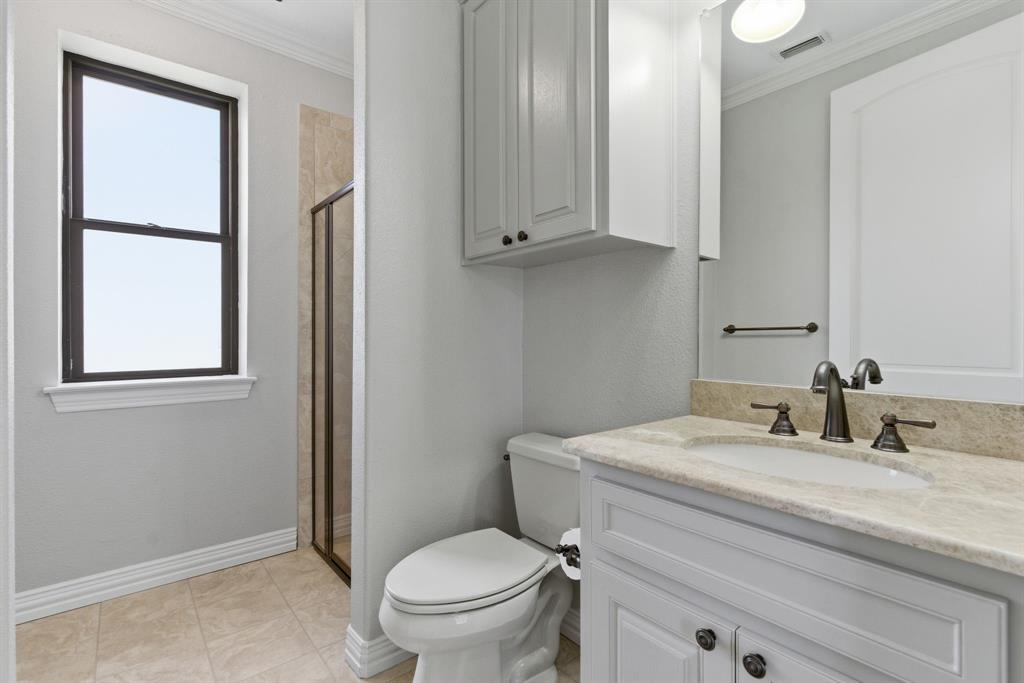 8970 Burnett Road Justin, TX 76247 - Photo 25 of 39 a bathroom with a toilet sink vanity and mirror