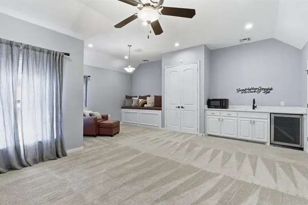 a large white bed in a white room and a dresser