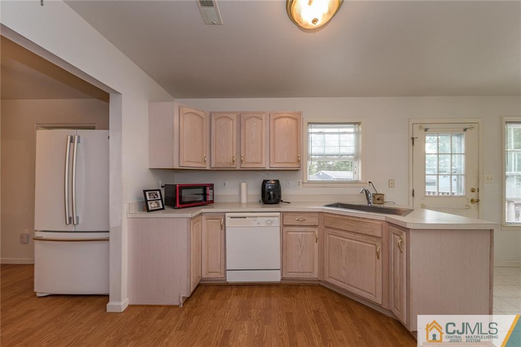132 Launch Road Manahawkin, NJ 08050 - Photo 6 of 25 a kitchen with stainless steel appliances granite countertop a sink a stove a refrigerator with grey cabinets