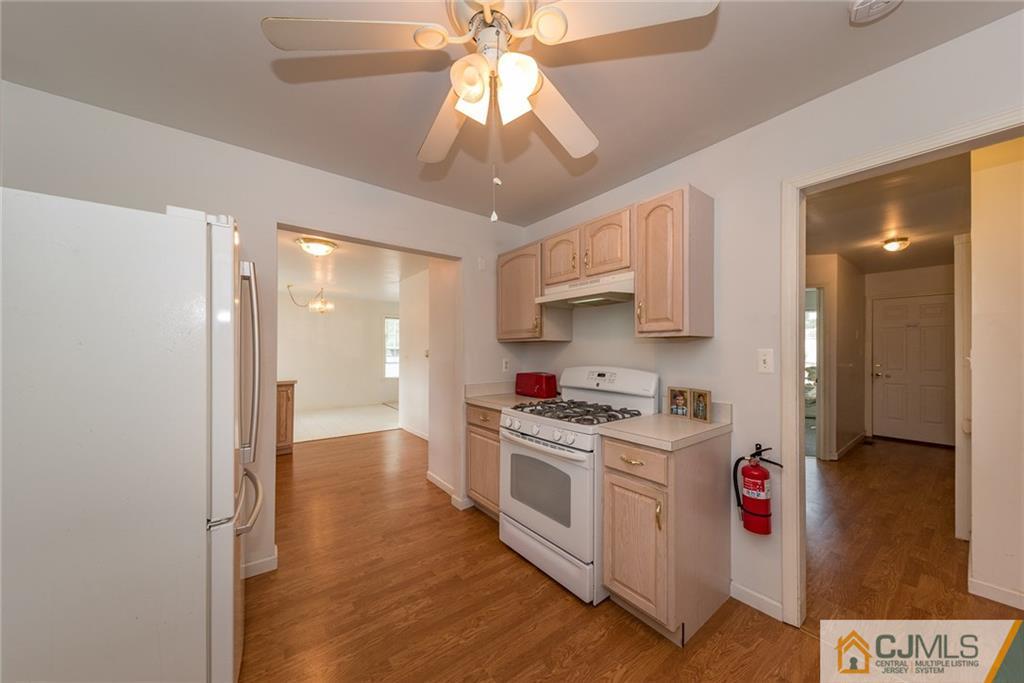 132 Launch Road Manahawkin, NJ 08050 - Photo 8 of 25 a kitchen with a stove a refrigerator and a chandelier