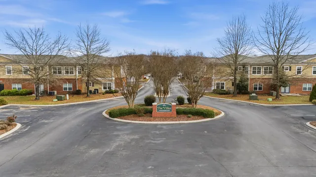 a front view of a building with trees around