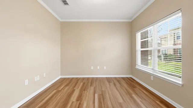 a view of a room with wooden floor and a window