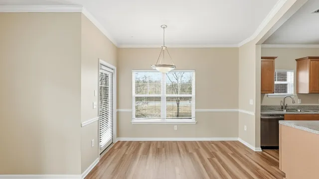 a view of a room with a window and hardwood floor