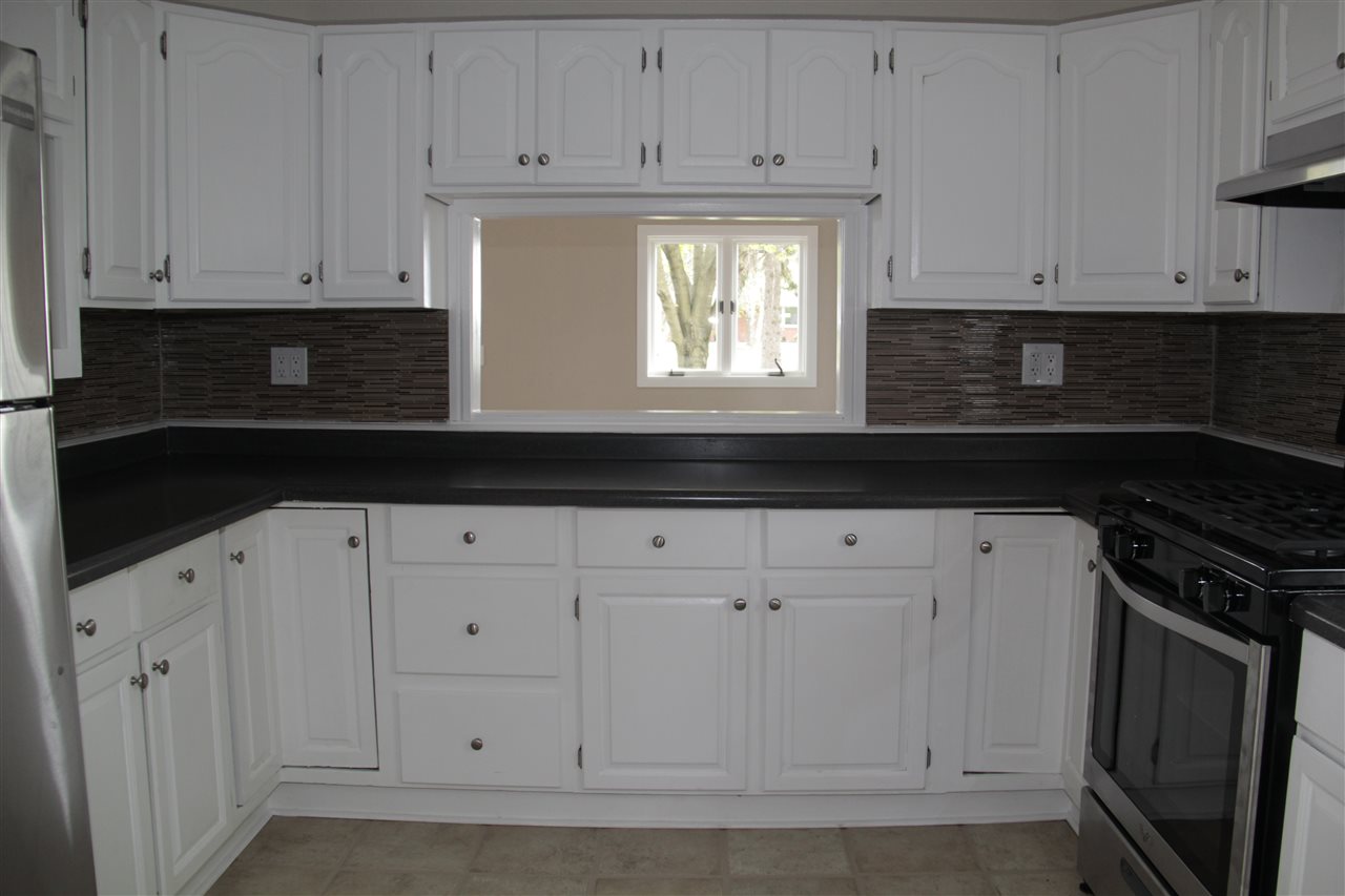 3618 Rotary Road Rockford, IL 61109 - Photo 8 of 24 a kitchen with white cabinets and black appliances