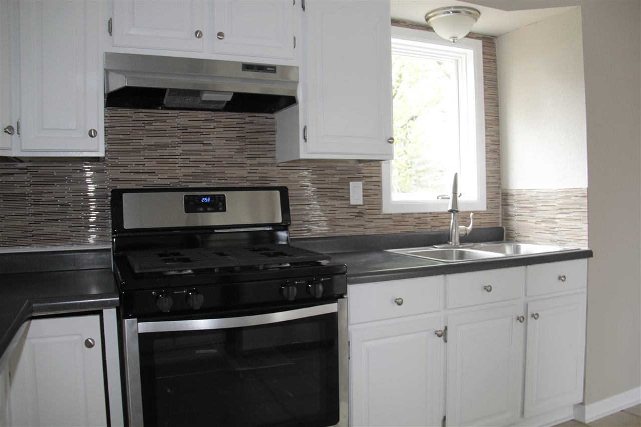 3618 Rotary Road Rockford, IL 61109 - Photo 9 of 24 a kitchen with granite countertop white cabinets and black appliances