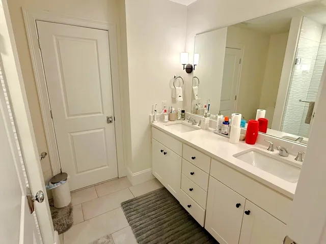 a bathroom with a double vanity sink mirror and toilet
