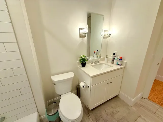 a bathroom with a sink mirror vanity and toilet