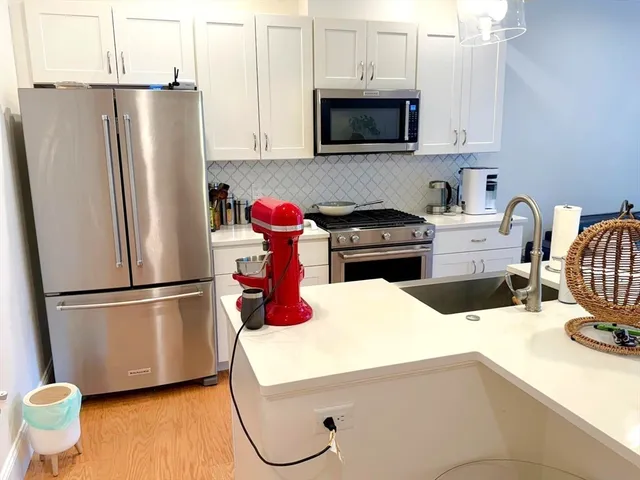 a kitchen with stainless steel appliances a refrigerator stove microwave and sink