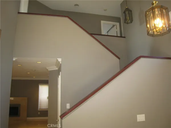 a view of a hallway with wooden floor and a kitchen space