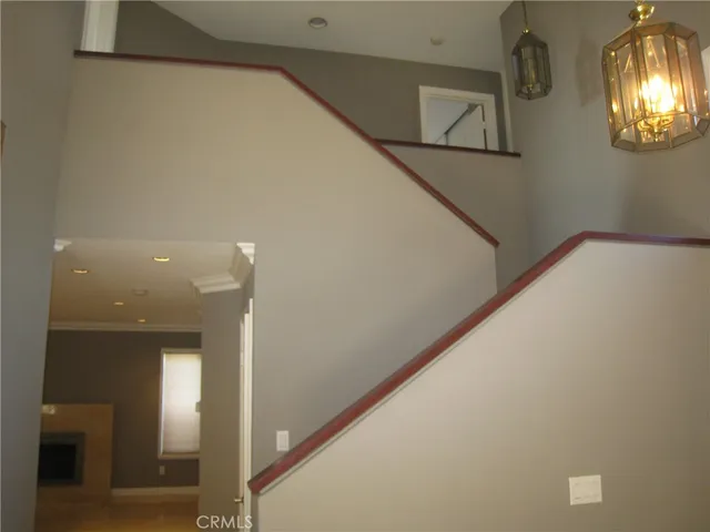 a view of a hallway with wooden floor and a kitchen space