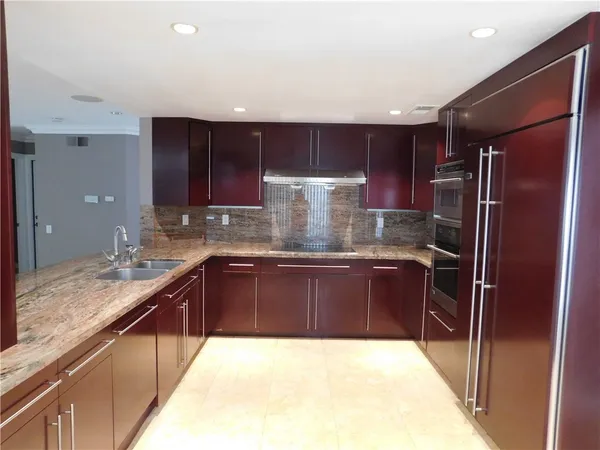 a kitchen with stainless steel appliances granite countertop a refrigerator and a sink