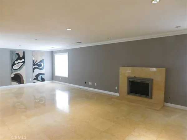 an empty room with windows and fireplace
