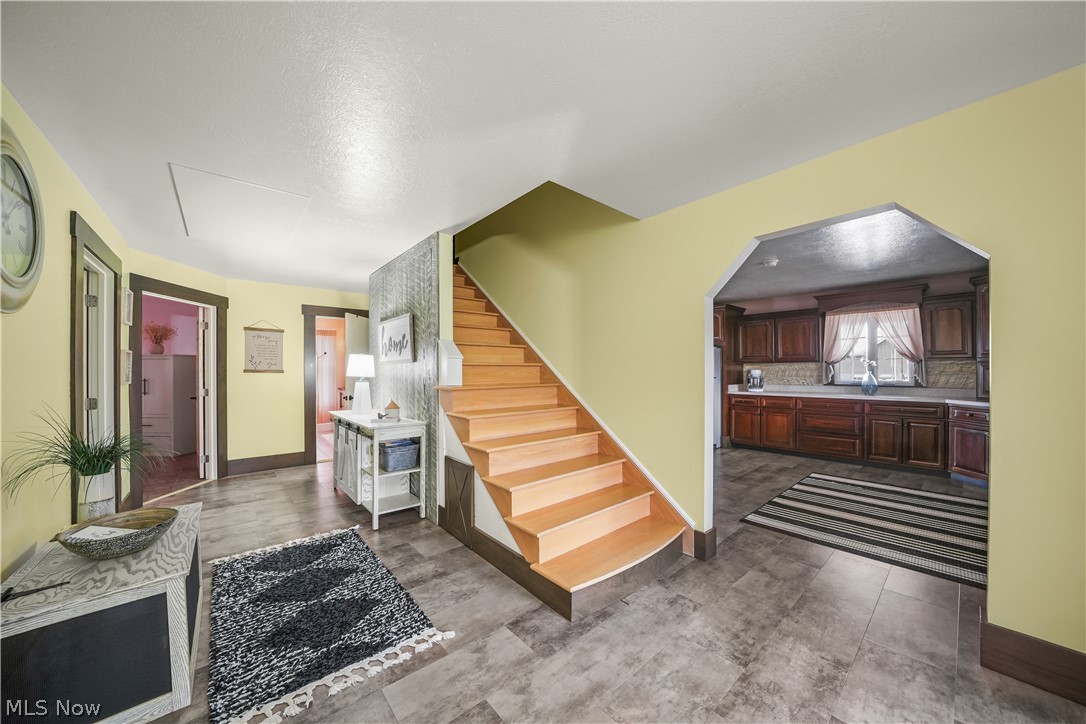 9561 Creaser Road North Bloomfield, OH 44450 - Photo 9 of 45 Staircase with arched walkways and a textured ceiling