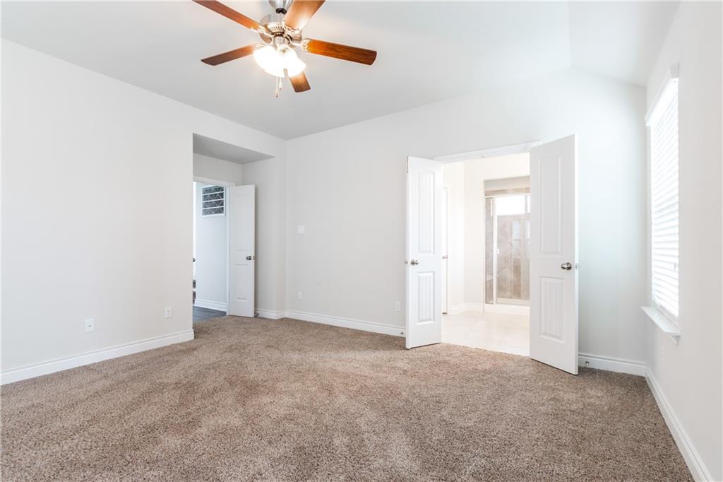 2104 Pindos Pony Way Georgetown, TX 78626 - Photo 15 of 30 A spacious primary bedroom features soft carpet and direct access to a private bathroom.