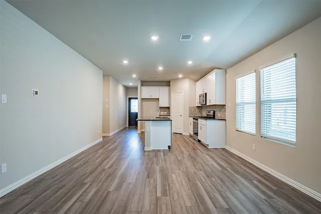 a kitchen with a refrigerator and a stove top oven