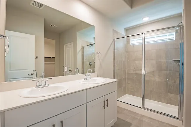 a bathroom with a shower sink and mirror