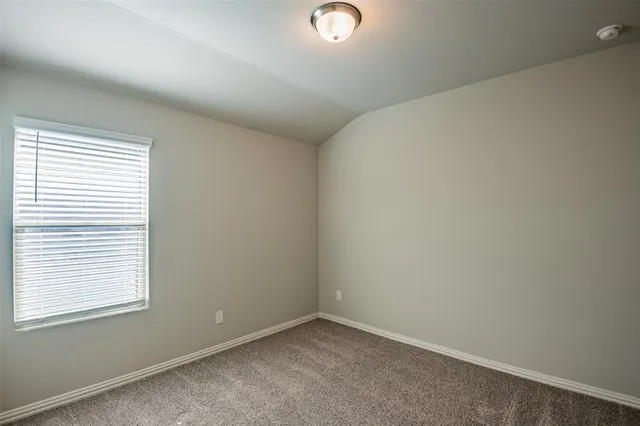 an empty room with closet and windows