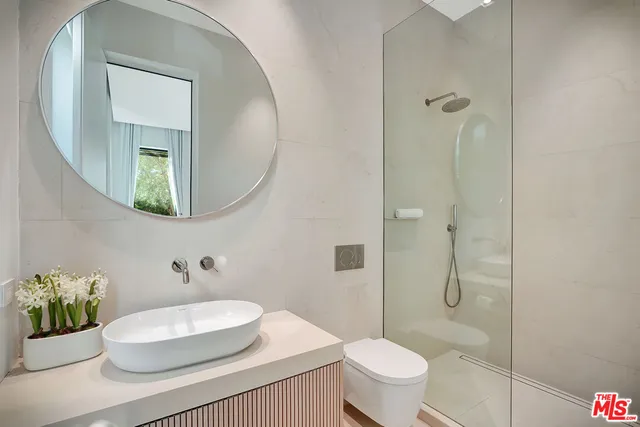 a bathroom with a toilet a sink and mirror