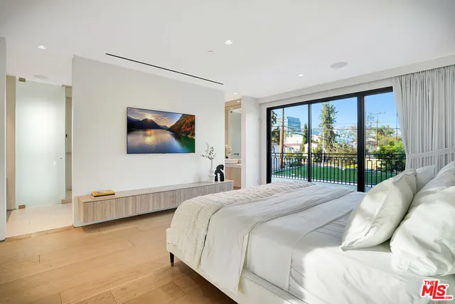 a bedroom with a large bed and a flat screen tv