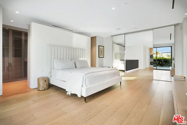 a bedroom with a bed and a large mirror