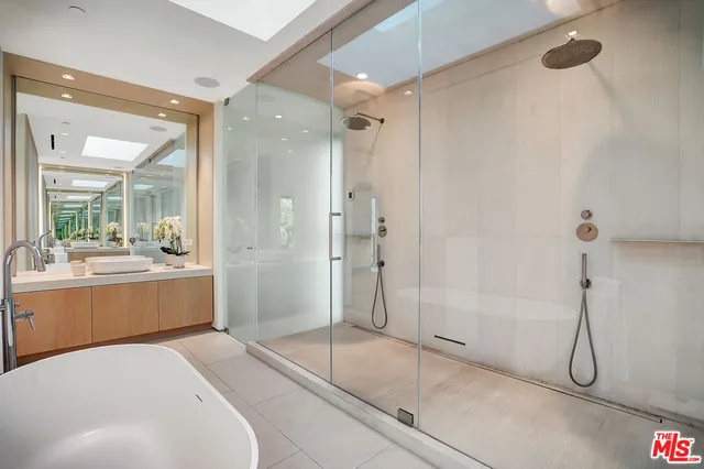 a bathroom with a sink a mirror and a shower