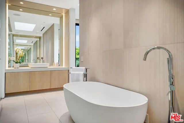 a bathroom with a white tub shower and sink