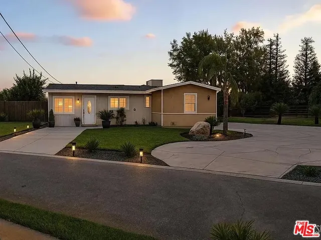 a view of a house with backyard and a tree