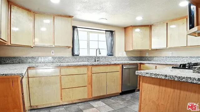 a kitchen with granite countertop cabinets sink and window