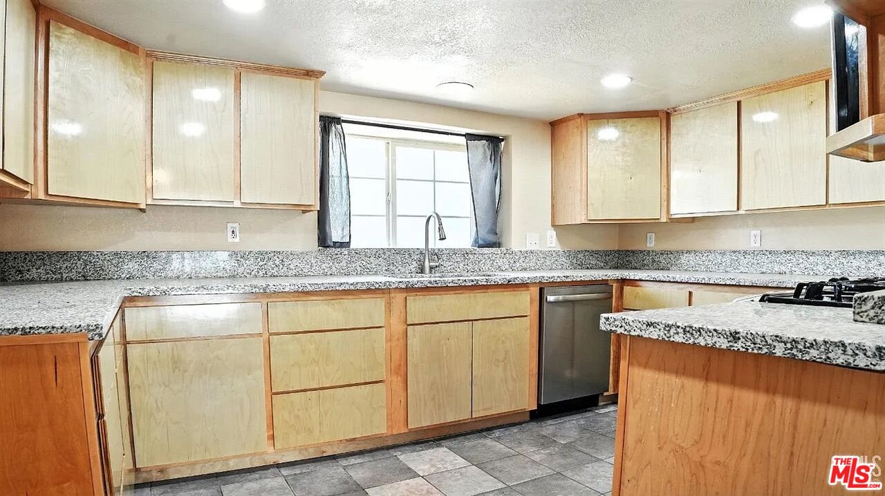 10931 Shellabarger Road Bakersfield, CA 93312 - Photo 12 of 44 a kitchen with granite countertop cabinets sink and window