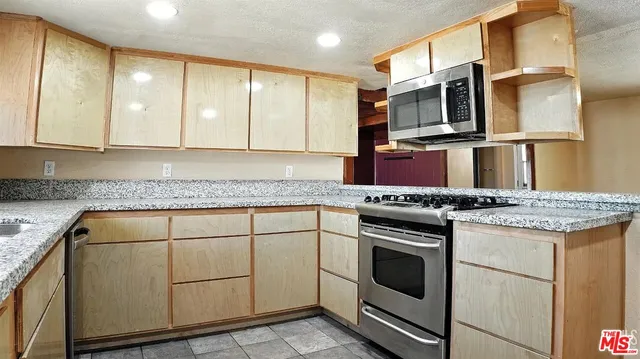 a kitchen with stainless steel appliances granite countertop a stove and a microwave