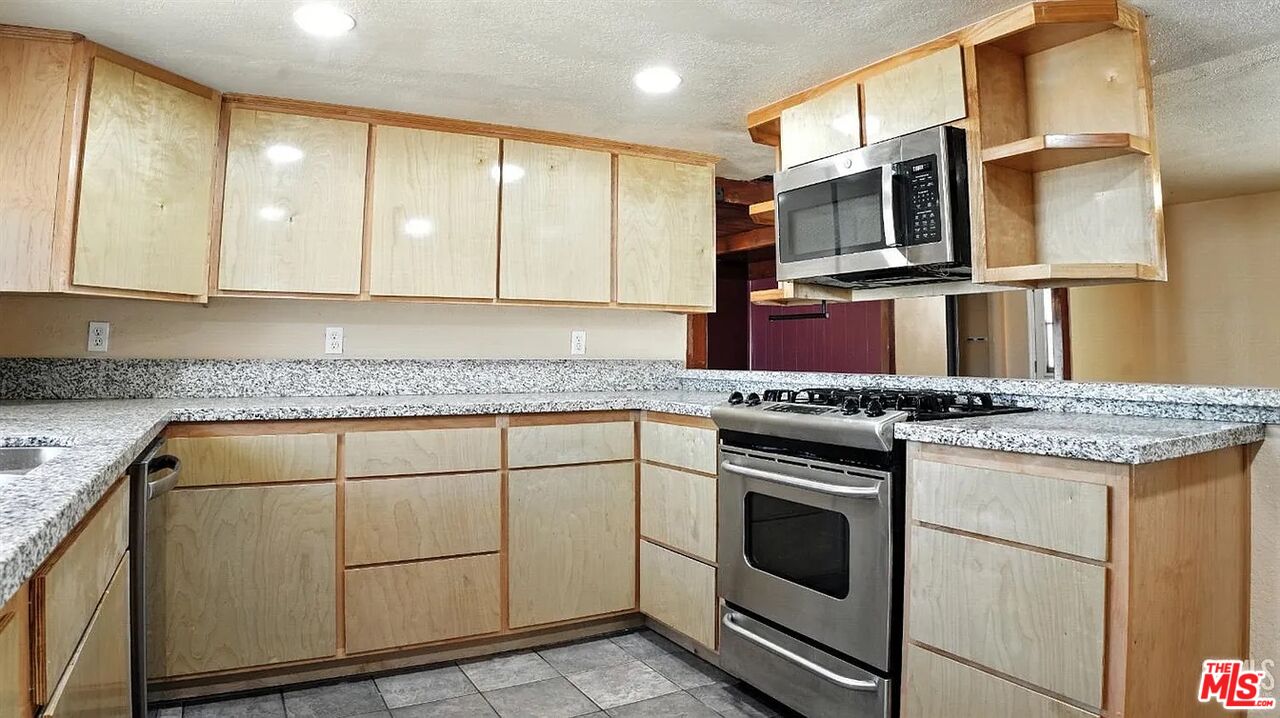 10931 Shellabarger Road Bakersfield, CA 93312 - Photo 14 of 44 a kitchen with stainless steel appliances granite countertop a stove and a microwave