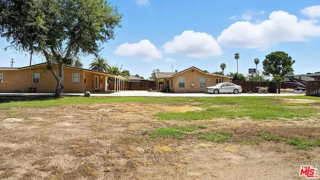 a view of a house with a yard and a fountain