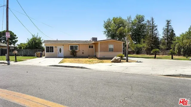a front view of house with yard and trees around
