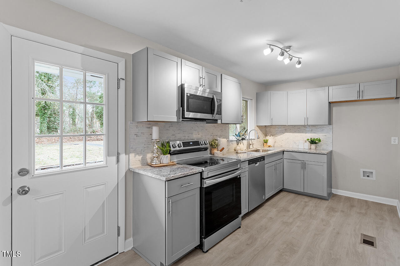 1610 Crescent Drive Spring Lake, NC 28390 - Photo 2 of 21 a kitchen with a sink stove top oven and cabinets