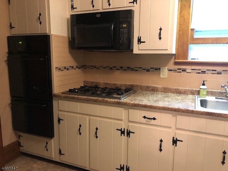32 West Maple Avenue Bound Brook, NJ 08805 - Photo 7 of 12 a kitchen with granite countertop white cabinets and black appliances
