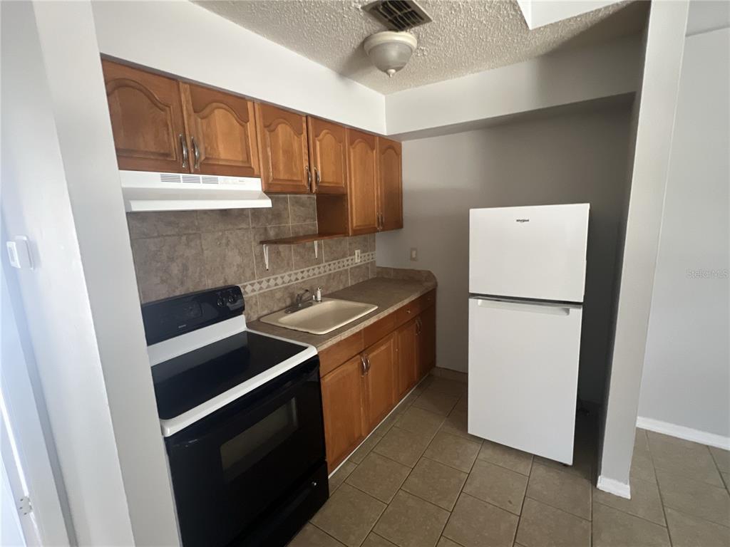 11558 Southeast 58th Avenue Belleview, FL 34420 - Photo 3 of 26 a kitchen with a refrigerator sink and cabinets