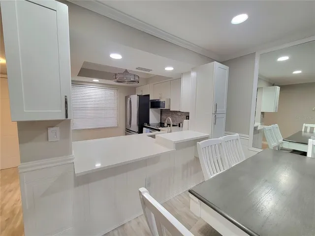a large white kitchen with a large window