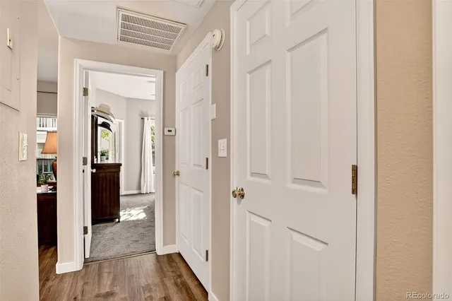 a view of a hallway with wooden floor and closet area