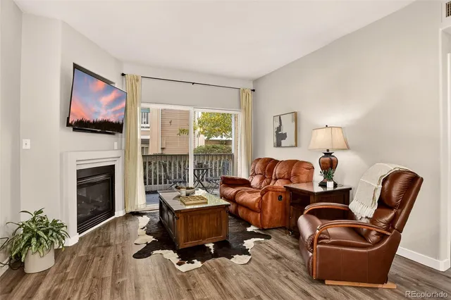 a living room with furniture a flat screen tv and a fireplace