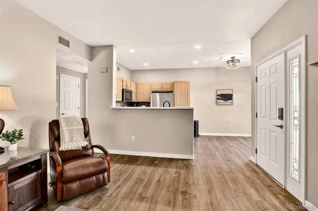 a living room with furniture and a wooden floor