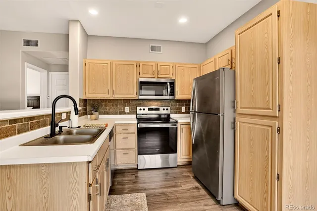 a kitchen with a refrigerator sink and stainless steel appliances