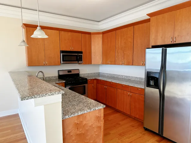 a kitchen with stainless steel appliances granite countertop a stove a sink and a microwave