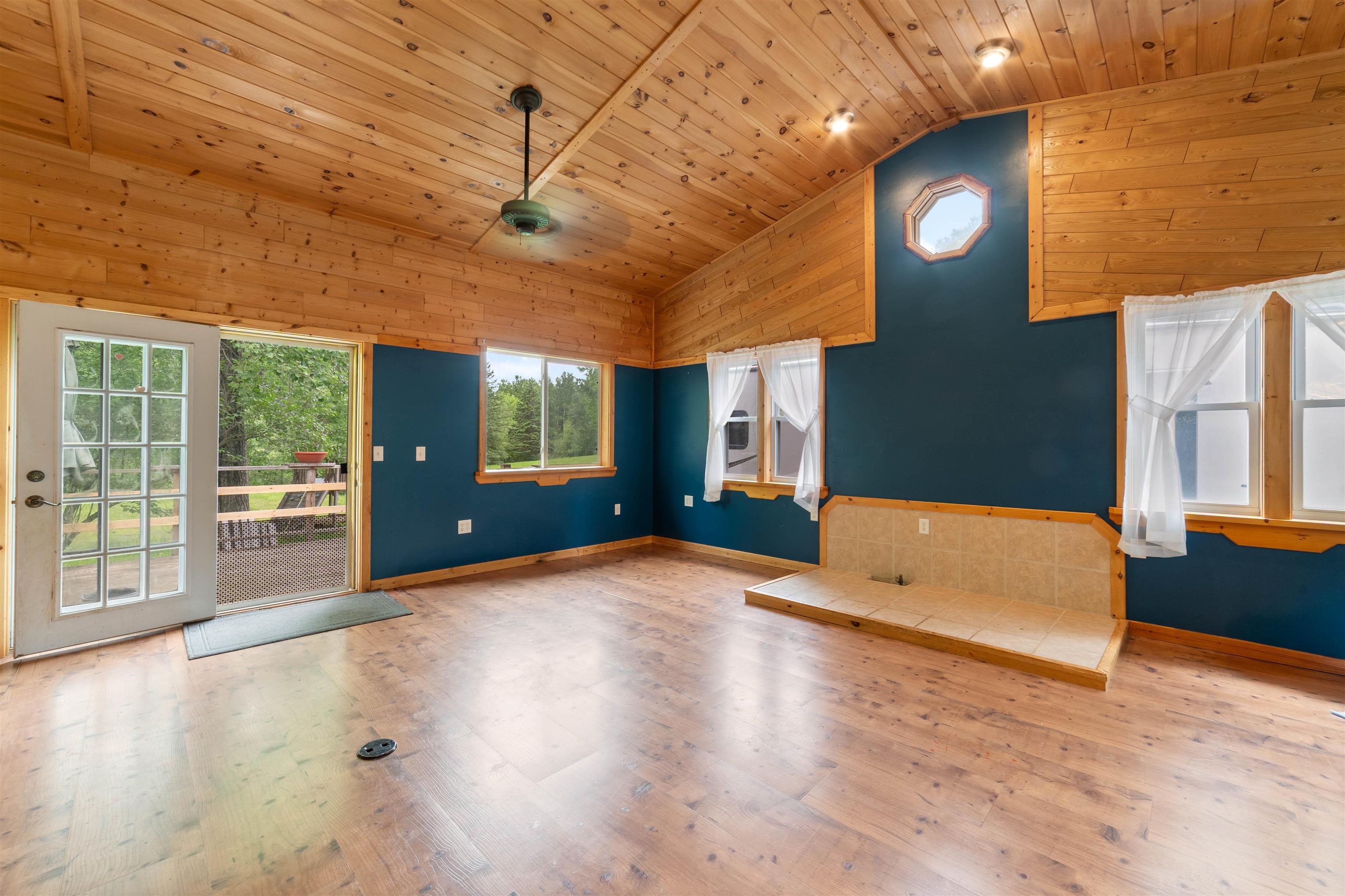 4767 McComber Road Duluth, MN 55803 - Photo 3 of 26 Unfurnished living room with wood ceiling, lofted ceiling, wooden walls, and wood finished floors
