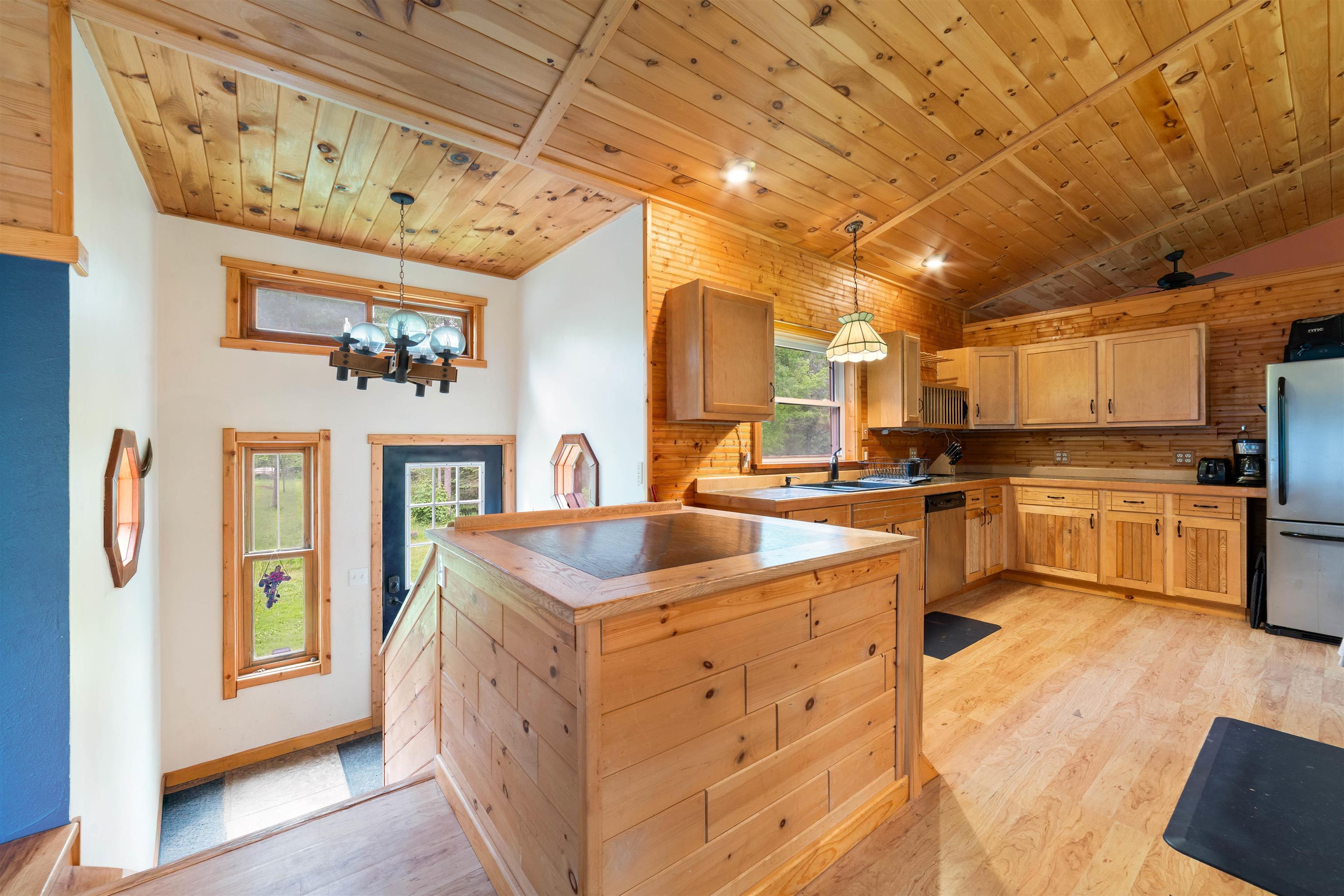 4767 McComber Road Duluth, MN 55803 - Photo 4 of 26 Kitchen featuring appliances with stainless steel finishes, light wood-type flooring, vaulted ceiling, wooden ceiling, and a chandelier