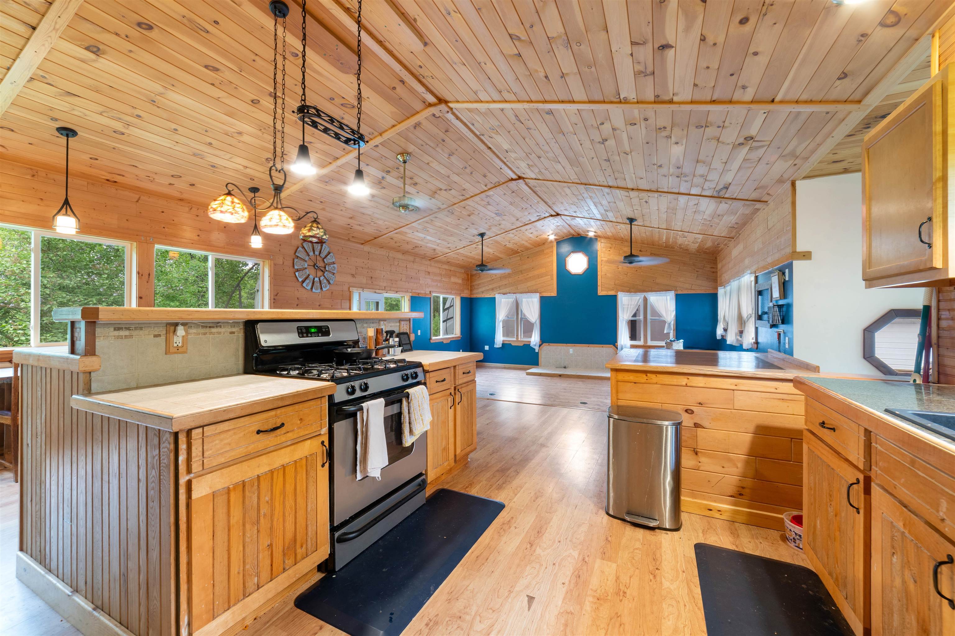 4767 McComber Road Duluth, MN 55803 - Photo 25 of 26 Kitchen with stainless steel range with gas cooktop, lofted ceiling, open floor plan, light wood-type flooring, and a kitchen island